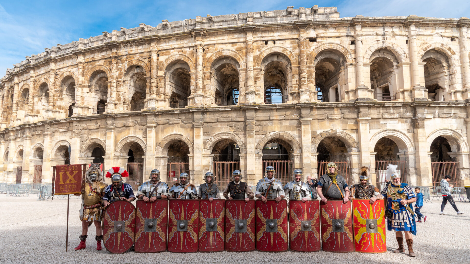 Scène de reconstitution antique avec gladiateurs et soldats romains devant les arènes de Nîmes, illustrant les Journées romaines.